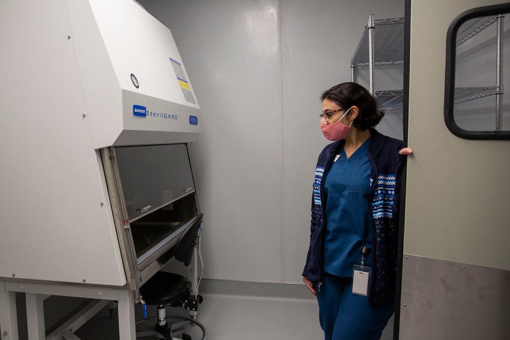 Research pharmacist Claire Fawzy enters the hazardous material lab at NEXT Oncology.  To be a phase one research site, clinics have to have a specialized pharmacy and equipment, plus staffers with expertise to run them.